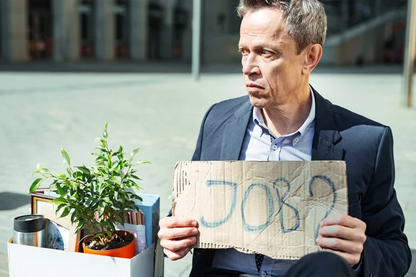 Hombre mayor con camisa azul sosteniendo cartel mientras busca empleo — Foto de Stock