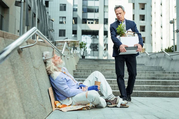 Fattiga svälter man sittande på golvet utanför kontoret — Stockfoto