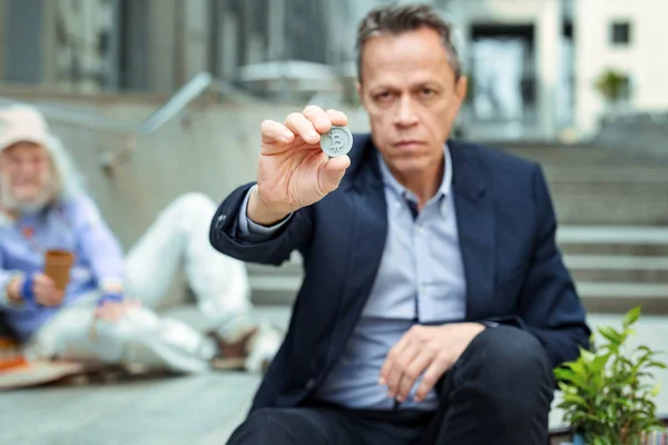 Businessman holding underground token in his hand — Stock Photo, Image