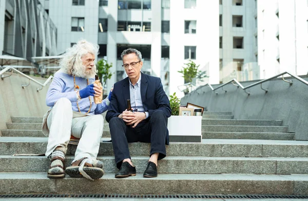 İki buruşuk adam ofis binası dışında bira içmek