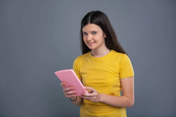 Bastante adolescente posando con una tableta rosa —  Fotos de Stock