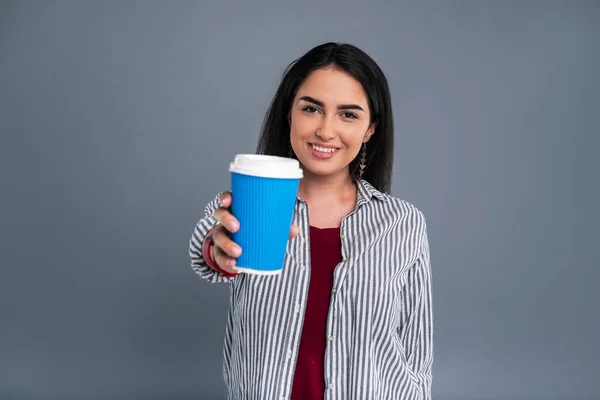 Encantadora mujer morena mostrando una taza de café azul — Foto de Stock