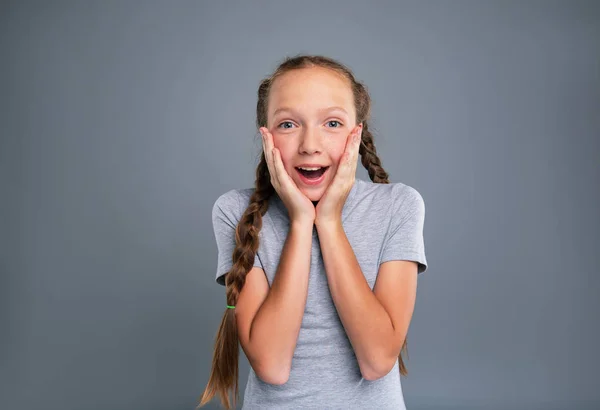 Alegre adolescente menina cupping ela bochechas e ser surpreendido — Fotografia de Stock