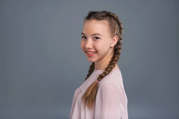 Menina adolescente alegre posando meio virada e sorrindo — Fotografia de Stock