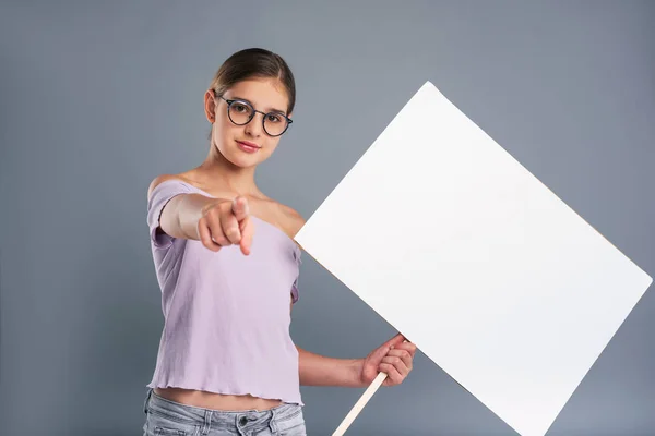 Linda adolescente sosteniendo pancarta y señalando — Foto de Stock