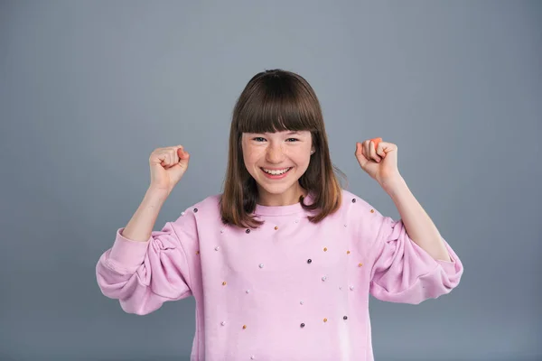 Jovencita alegre levantando los puños en celebración — Foto de Stock