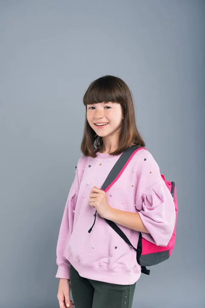 Веселая девочка-подросток с рюкзаком на плече — стоковое фото