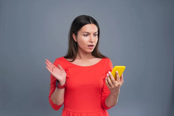 Pleasant young woman being surprised by message — Stock Photo, Image