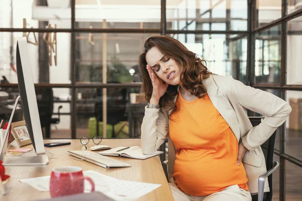 Sick pregnant CEO suffering from headache — Stock Photo, Image