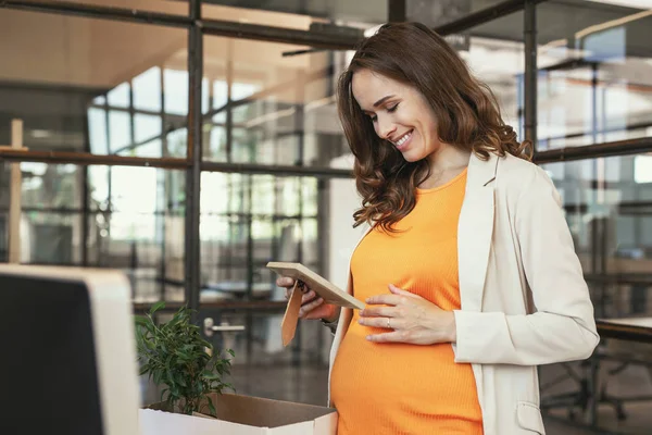 Щасливий вагітний працівник захоплюється фотографією — стокове фото