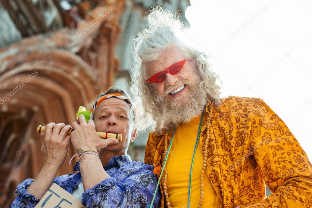 Beaming smiling hippies wearing bright stylish shirts