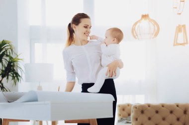 Genç ve güzel kadın çocuğunu tutan