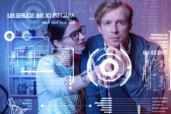 Cute wife looking at her husband and pointing to the screen — Stock Photo, Image