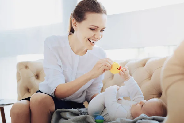 Feliz persona femenina dando juguete a su bebé — Foto de Stock