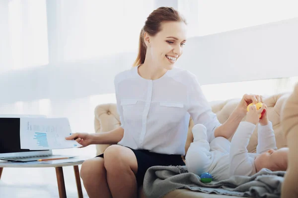 Joyful young mommy taking rubber duck — Stock Photo, Image