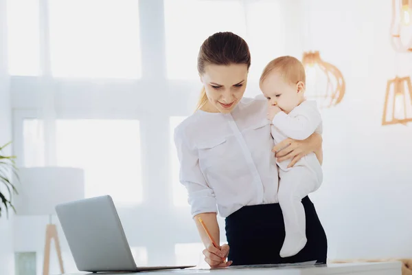 Uppmärksamma affärskvinna arbetar med sitt barn — Stockfoto