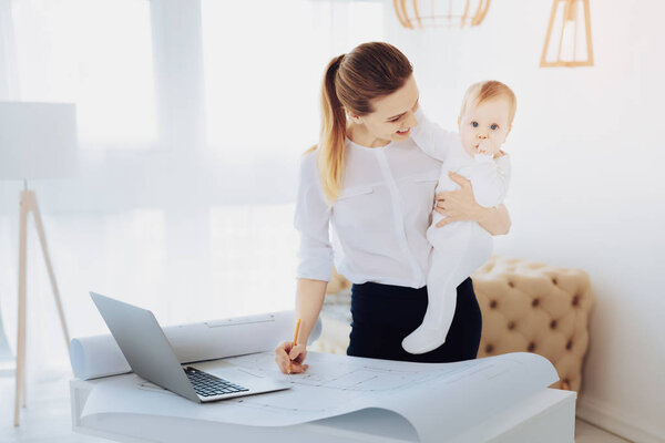 Радостная деловая женщина, играющая со своим ребенком
