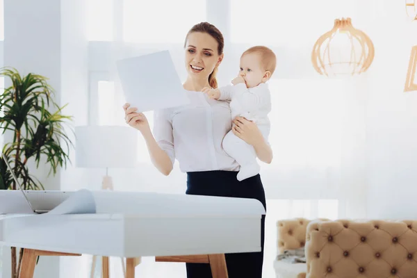 Glada unga mamma att undersöka hennes anteckningar — Stockfoto