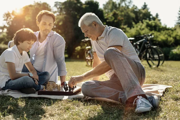 Lycklig familj spelar schack i naturen — Stockfoto
