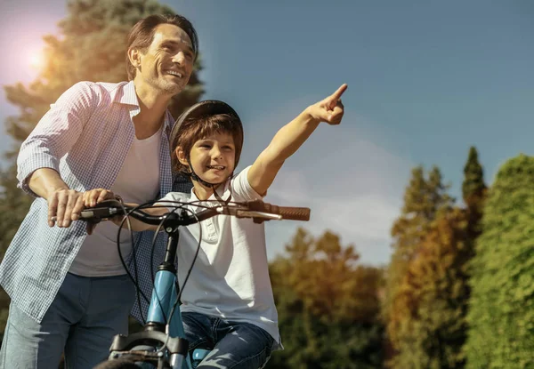 Menino equitação seu bicicleta com papai de pé — Fotografia de Stock