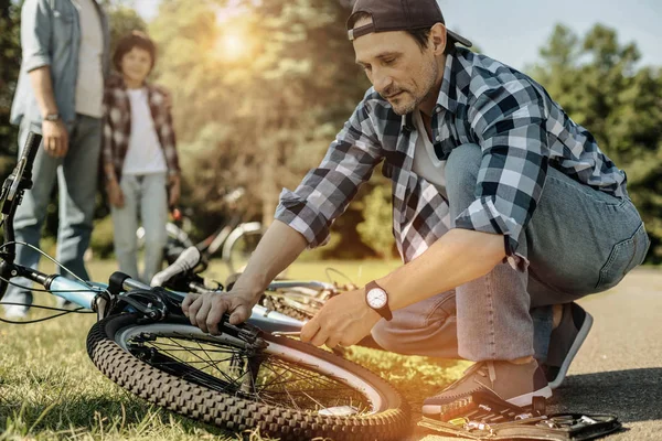 Liebender Papa repariert Fahrrad seiner Söhne — Stockfoto