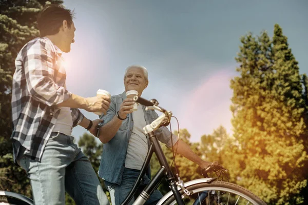 Расслабленные мужчины катаются на велосипедах и пьют кофе — стоковое фото