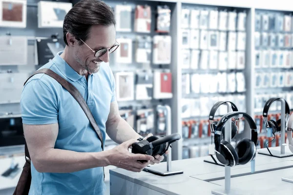 Spokojený zákazník při pohledu na nové černé sluchátka — Stock fotografie