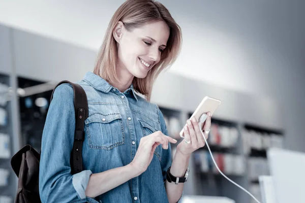Cute smiling woman looking at the new device — Stock Photo, Image