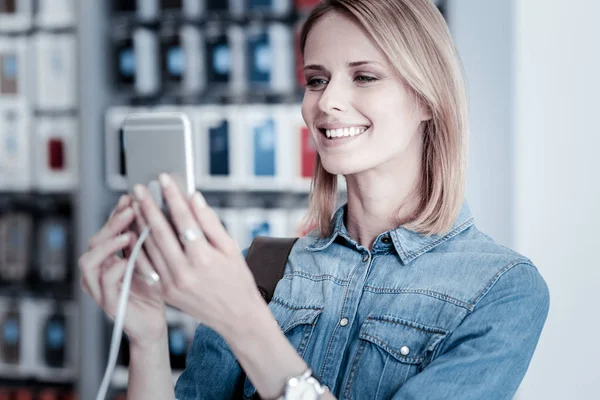 Lachende vrouw bewonderende nieuwe modieuze smartphone — Stockfoto