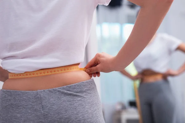 Joven hembra manos medición cintura — Foto de Stock