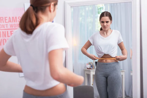 Unzufriedene Teenagerin kontrolliert Gewichtszunahme — Stockfoto