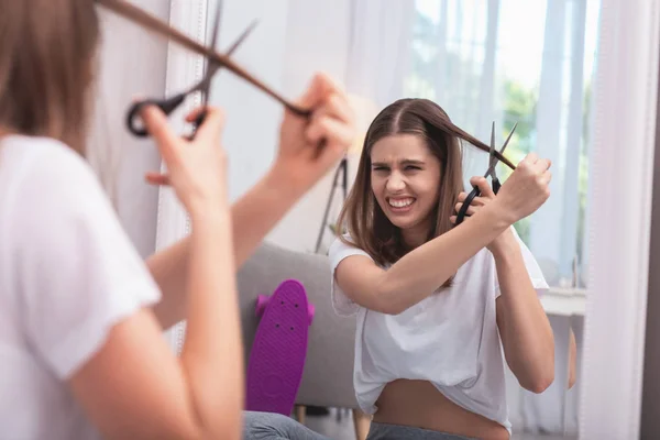 Annoyed teen girl altering haircut — Stock Photo, Image