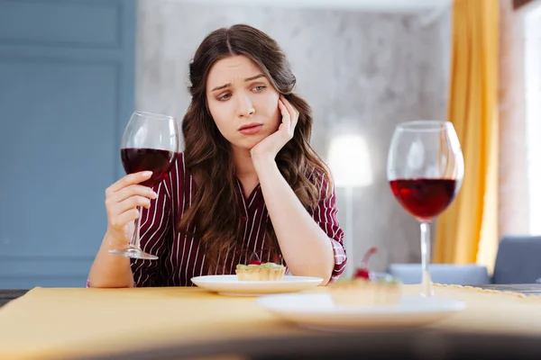 Mujer morena usando blusa rayada sintiéndose triste — Foto de Stock