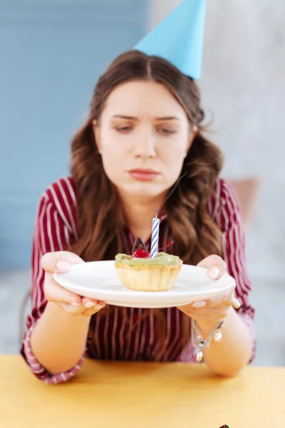 Женщина с белой тарелкой и маленьким праздничным тортом — стоковое фото