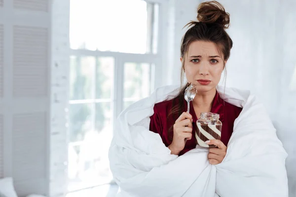Stressed woman holding little spoon in her hand — Stock Photo, Image