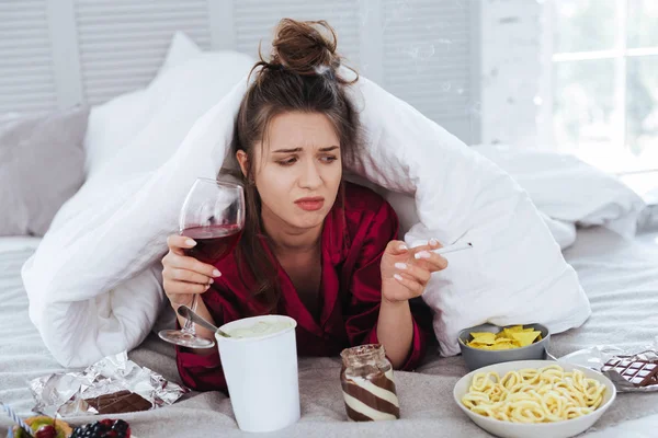 Mujer estresada pasando una noche solitaria con vino y comida — Foto de Stock