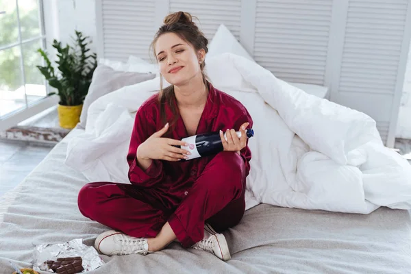 Mujer estresada volviéndose loca sosteniendo una botella de champán — Foto de Stock