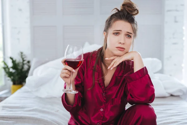 Eenzame vrouw het dragen van pyjama drinken van alcohol alleen — Stockfoto