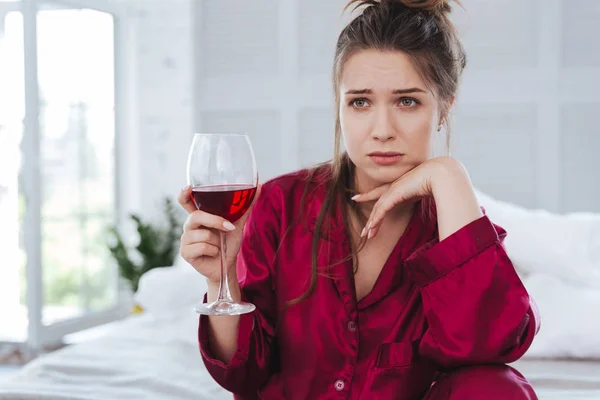 Groen-eyed vrouw in donker-rode pyjama vreselijke gevoel — Stockfoto