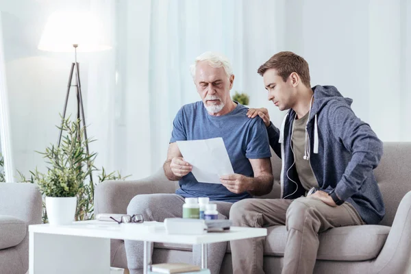 Earnest senior man showing medication list — Stock Photo, Image