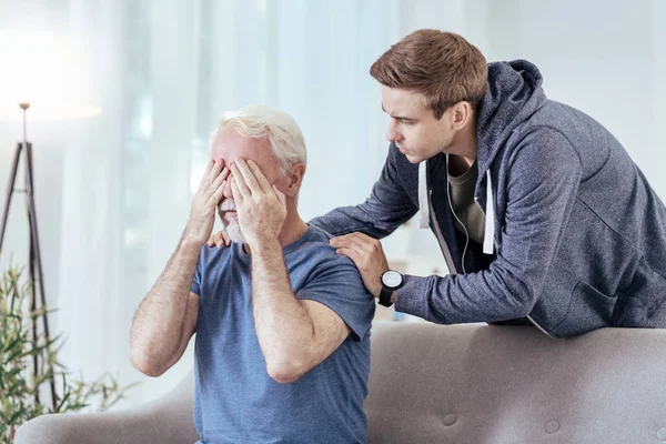 Uneasy man comforting senior man — Stock Photo, Image