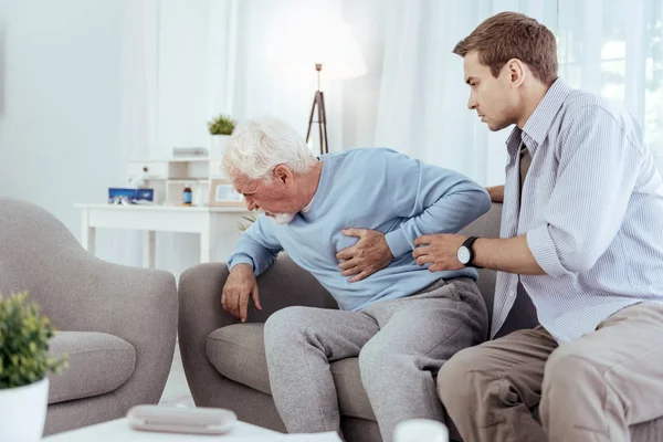 En bekymret mann hjelper en eldre mann. – stockfoto