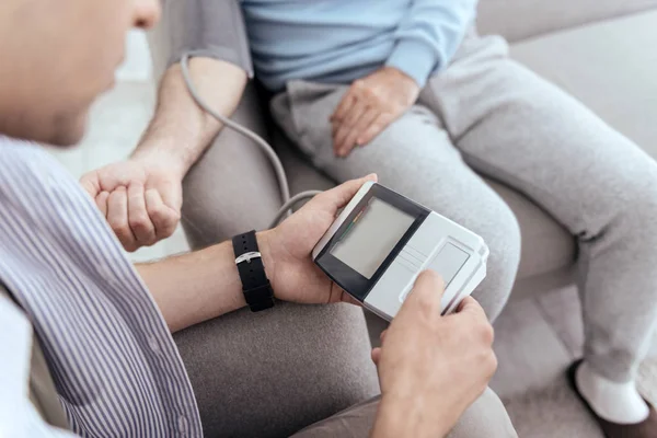 Joven manos masculinas monitoreando la presión arterial — Foto de Stock