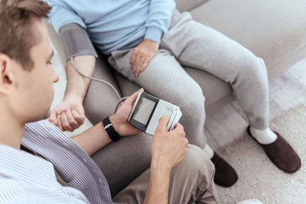 Cálmate Vista Superior Del Hombre Concentrado Usando Tonómetro Mirando Hacia — Foto de Stock