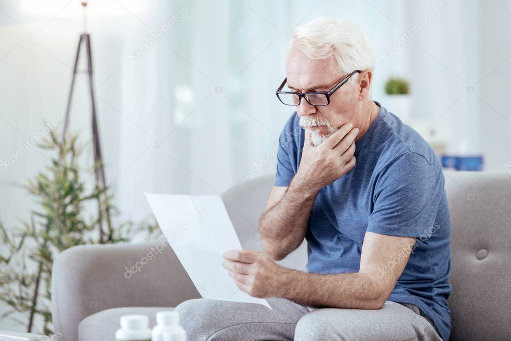 Pensive senior man studying instruction