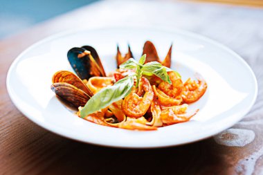 Makarna midye ve beyaz tabak içinde yalan roka ile