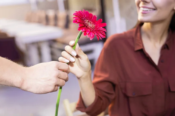 Молодая женщина чувствует борьбу, получая цветок — стоковое фото