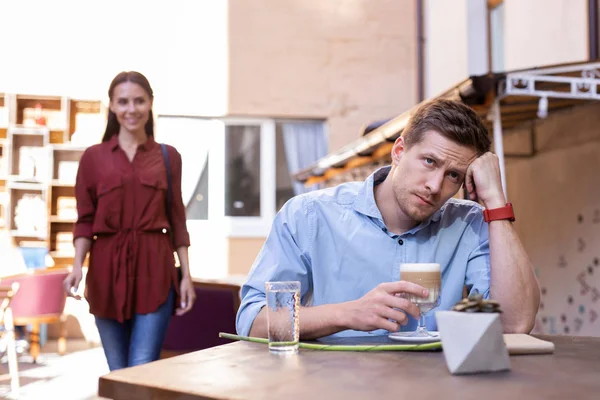 Красивий чоловік відчуває втому, чекаючи на свою дівчину на обід — стокове фото