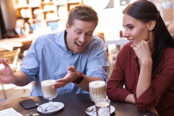 Fiatal aranyos pár ivás latte ül az étteremben — Stock Fotó