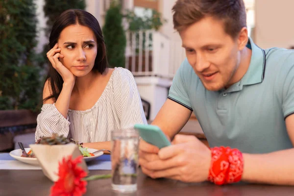 Attraktive Frau langweilt sich, während ihr Mann ihr keine Aufmerksamkeit schenkt — Stockfoto